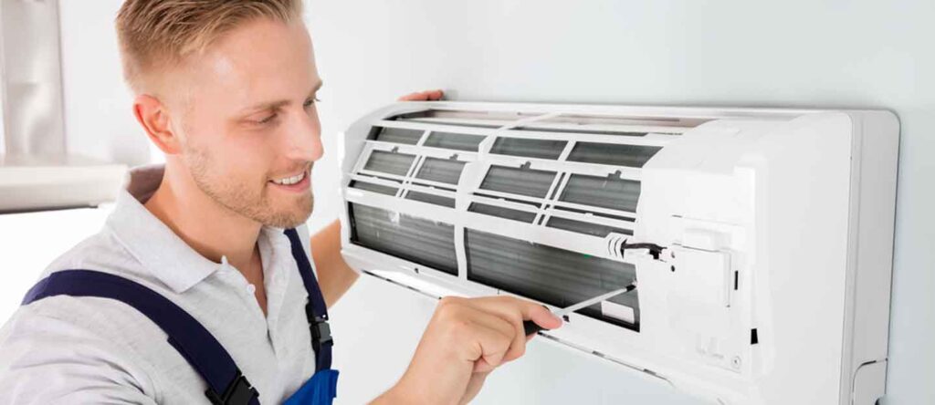 Technician repairing a modern air conditioning unit in Dubai home, professional AC service for cooling comfort