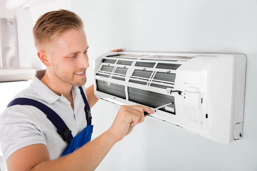 Leading Technicals expert inspecting and repairing AC unit in Dubai